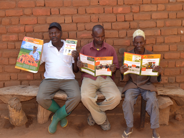 Vegetable farmers with SEVIA newsletters, crop guides and calendar